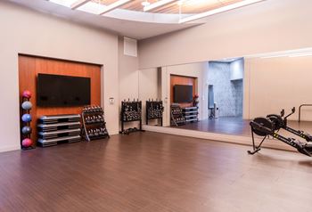 a large room with a drum set and a tv on the wall and a mirror at The Acadia at Metropolitan Park, Arlington, VA